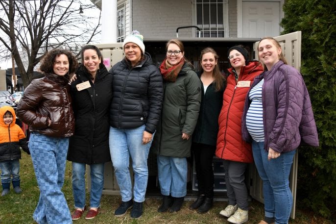 Group of seven women smiling together outdoors at the Local Maternity Thread clothing closet launch in Petworth