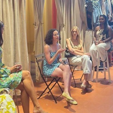 Four women engaged in a lively discussion in a cozy, warmly lit room